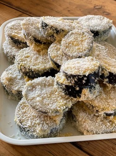Aubergine slices coated and ready to fry