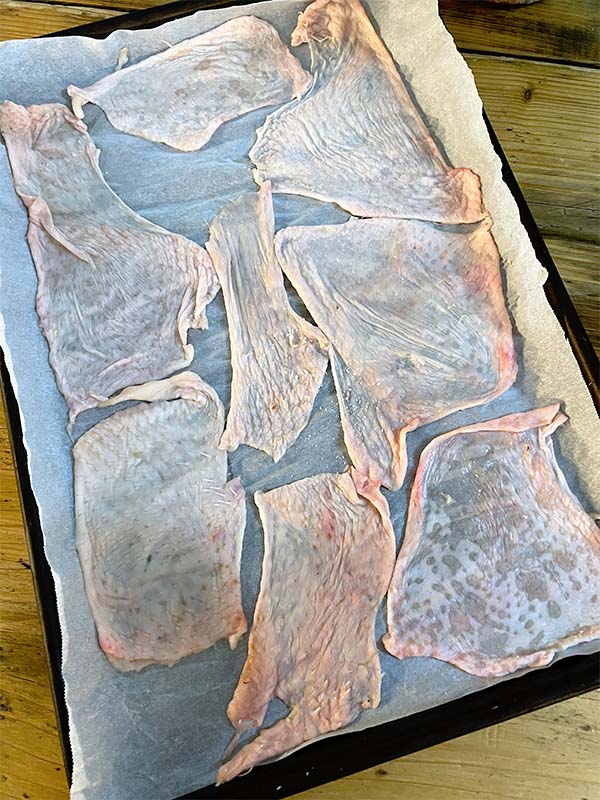 Crisp chicken skin stretched out ready to cook