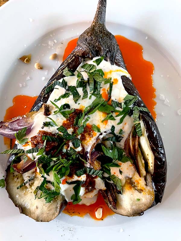 Roast aubergine stuffed with tomato and onion served