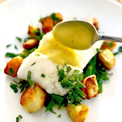 Halibut with butter sauce and wilted spinach served
