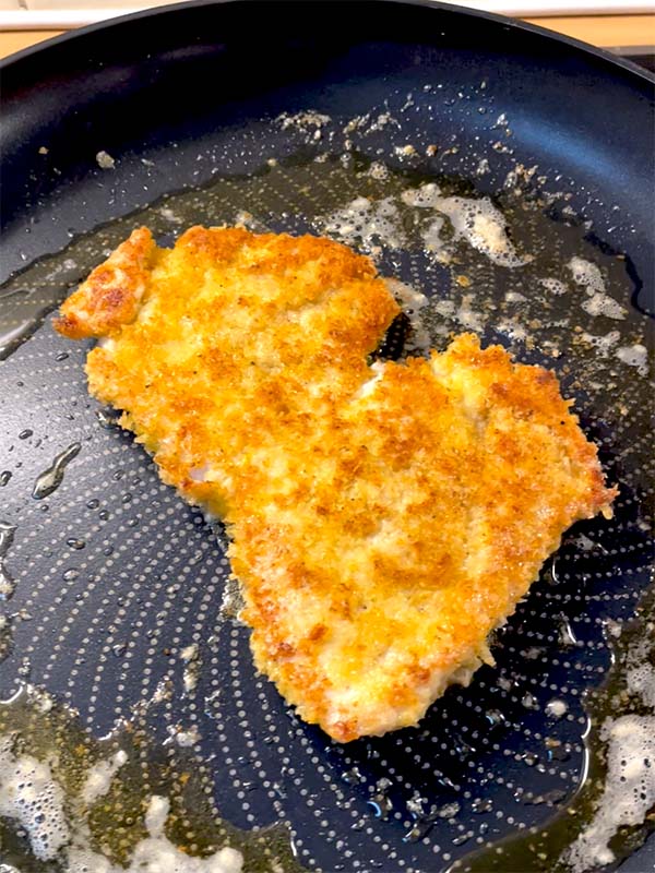Chicken Milanese frying in butter
