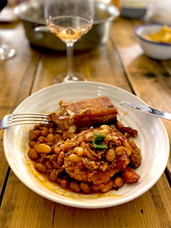 Cowboy beans served with a slice of pork belly