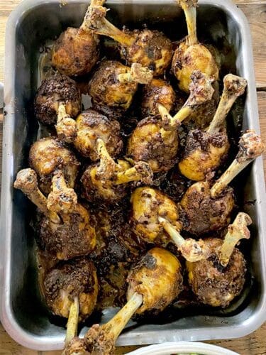 Spiced chicken lollipops in the roasting tray