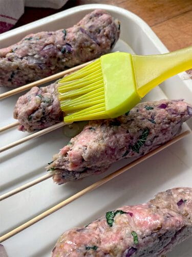 Brush the lamb koftas with oil